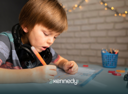 A kid writing on a paper at a table