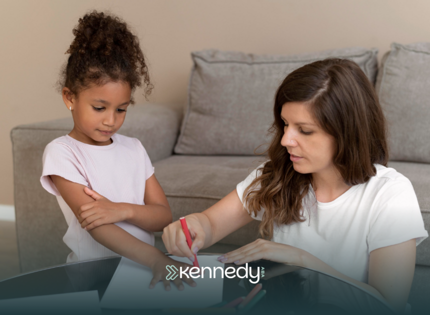 A BCBA and a girl using crayons during ABA therapy