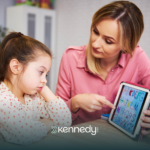 An ABA therapist using a mobile tablet, showing alphabet to a girl during ABA therapy