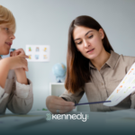 An ABA therapist showing a workbook to a kid during ABA therapy