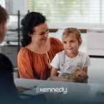 A mother holding her child talking to an insurance agent