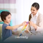 A kid and a BCBA playing with colorful blocks during ABA therapy