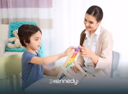 A kid and a BCBA playing with colorful blocks during ABA therapy