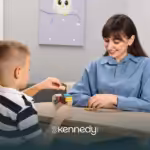 A BCBA observing a child playing with colorful wooden blocks